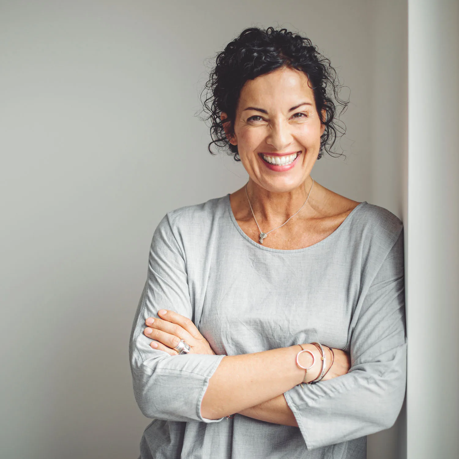 Eine ältere Dame, die lächelnd in die Kamera blickt.