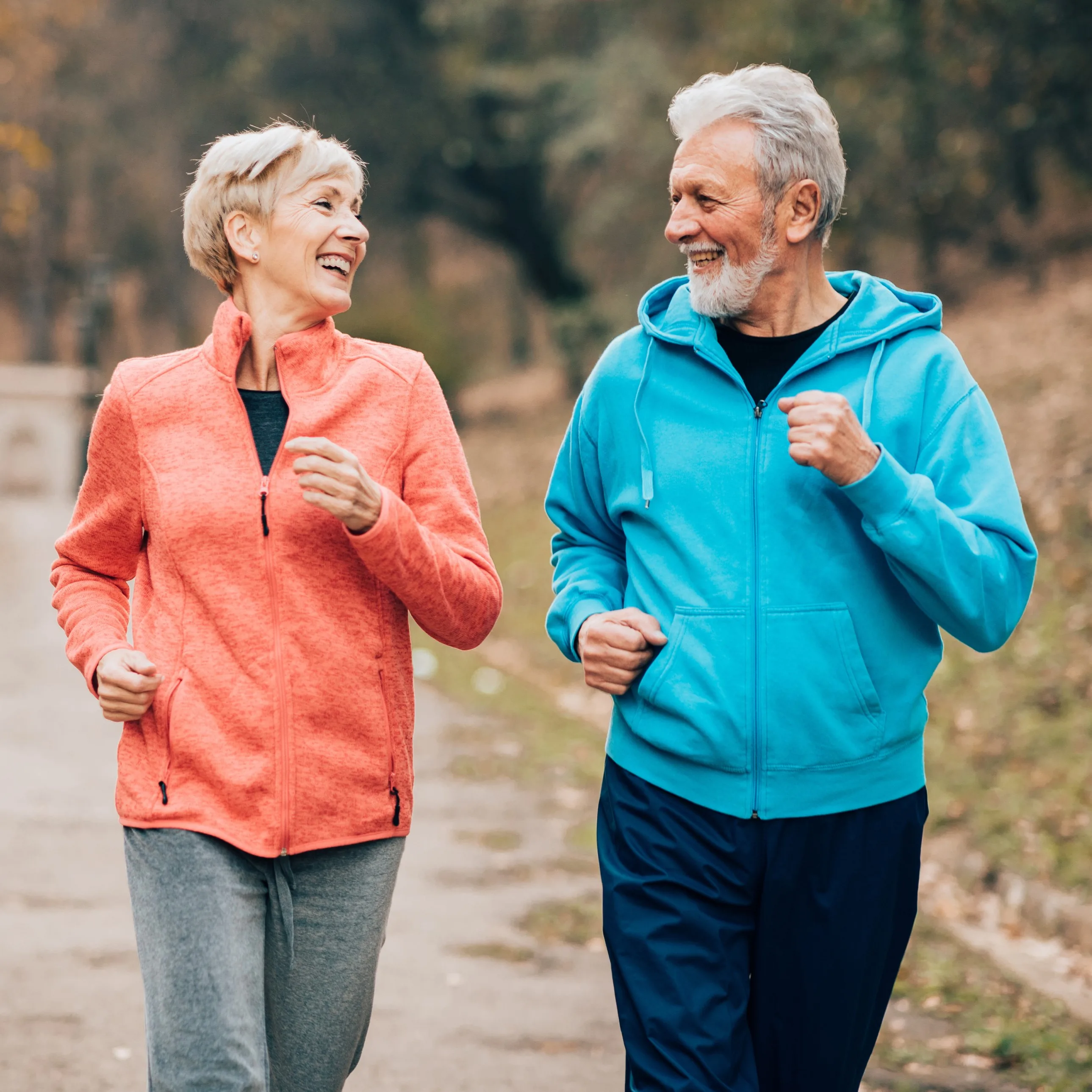 Ein älteres Päarchen joggt zusammen in der Natur.