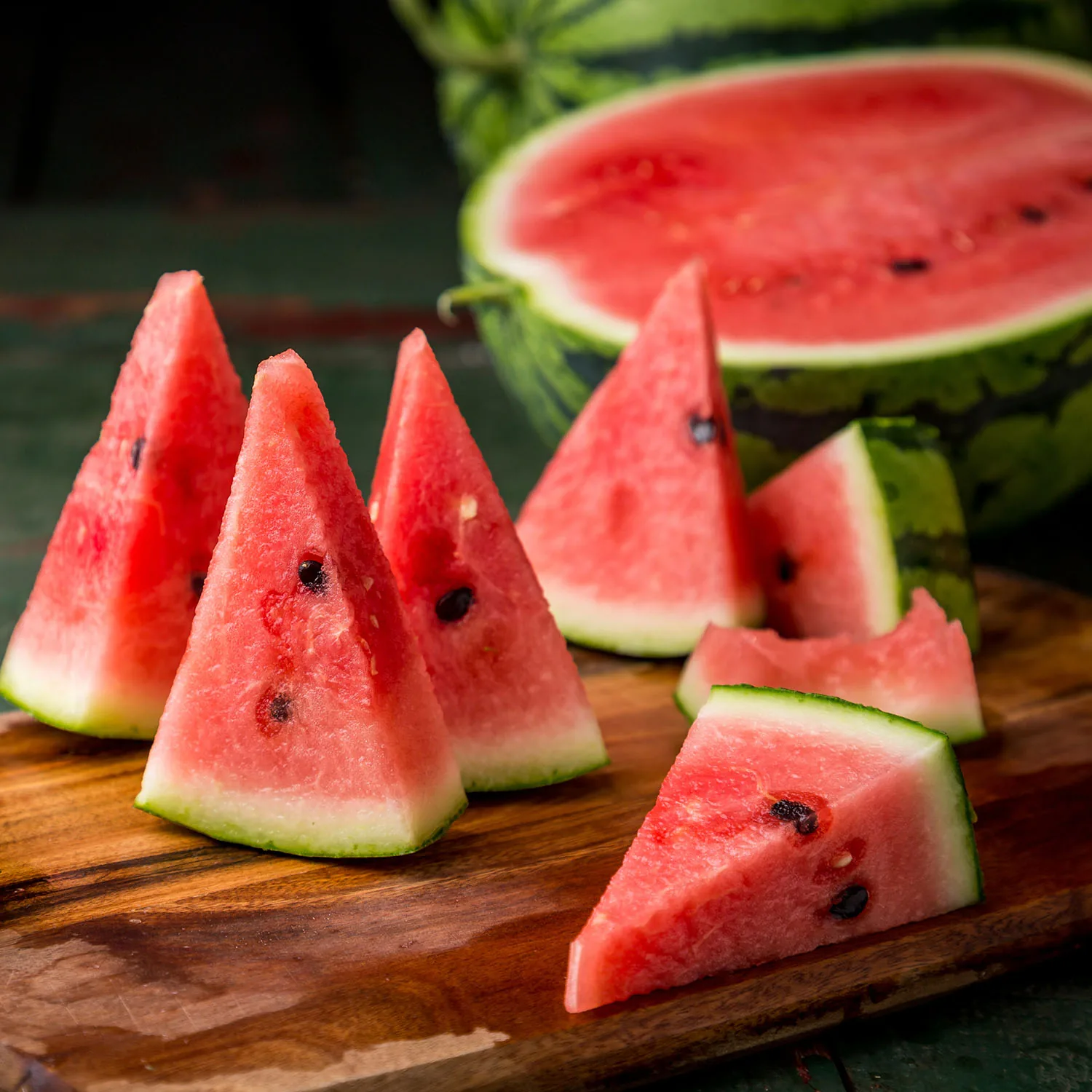 Aufgeschnittene Wassermelonenstücke auf einem Holzbrett.